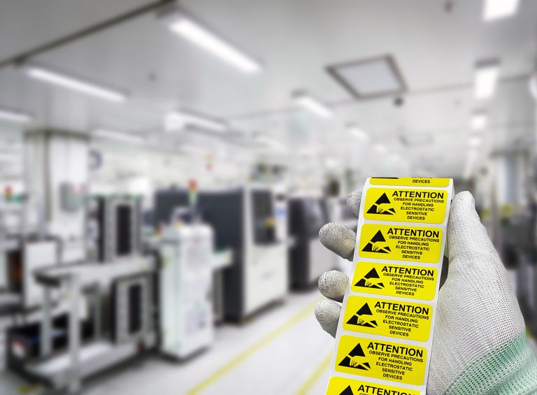 ESD stickers in a gloved hand on the manufacturing floor